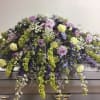 Lavender and green floral casket spray with cascading blooms