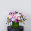 Pink and white mixed bouquet in a green glass vase