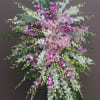 Tall standing arrangement of pink, white, and purple orchids