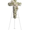 White floral cross on a stand with lilies and roses