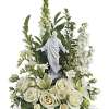 White floral arrangement with a religious statue centerpiece