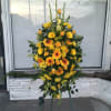 Tall yellow and orange floral standing spray on an easel