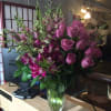 Pink roses and orchids arranged in a clear glass vase