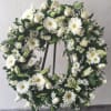 White floral wreath with daisies, roses, and lilies