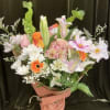 Mixed bouquet of lilies, roses, daisies, and orange gerbera daisies wrapped in pink paper