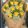 A cheerful bouquet featuring 12 fresh yellow roses wrapped in Kraft paper