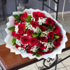 Bouquet of red roses with white baby's breath wrapped in white paper