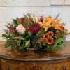 Mixed autumn bouquet with lilies, roses, chrysanthemums, and a small pumpkin