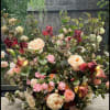 Large bouquet of peach, pink, and burgundy flowers with mixed greenery