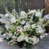 Large white floral arrangement with mixed blooms and berries
