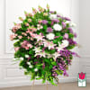 Large standing spray of pink, white, and purple flowers on an easel