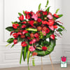 Large tropical arrangement with red and pink anthuriums and roses