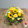 Yellow roses and sunflowers in a low glass vase with a ribboned succulent accent