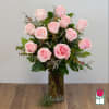Pink roses arranged in a tall glass vase