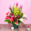 Tropical bouquet with pink ginger, orchids, and red anthuriums in a vase