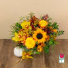 Yellow and orange floral arrangement in a vase with a white pumpkin