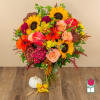 Colorful bouquet with sunflowers, roses, and anthuriums in a glass vase