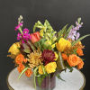 Colorful mixed bouquet in a glass vase with roses and snapdragons