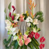 Tropical floral wreath with anthuriums and bird-of-paradise on a stand