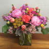 Colorful mixed bouquet in a glass vase with a striped ribbon