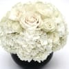 White roses and hydrangeas in a black vase