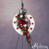 Red and white funeral wreath on a stand with roses and carnations