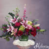 Pink lilies and red roses in a green glass vase