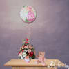 Pink baby girl balloon above a mixed flower arrangement with a teddy bear