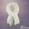 White floral funeral wreath with a ribbon border on a purple background