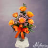Orange roses in a glass vase with a large orange ribbon