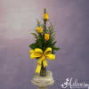 Tall arrangement of yellow roses in a glass vase with a large yellow bow