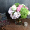 Pink and white roses with hydrangeas in a glass vase