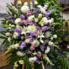 Large standing floral spray with white, pink, and purple blooms