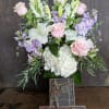 Bouquet of pink roses, white lilies, and lavender flowers in a vase