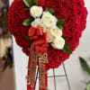 Heart-shaped red carnation arrangement with white roses and a red ribbon