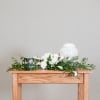 White floral funeral arrangement with an urn and memorial candle
