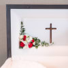 White and red floral casket spray with a cross