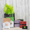 Gift bag with assorted candy boxes and treats on a wooden surface