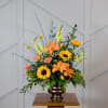 Colorful floral arrangement in a bronze vase with sunflowers and lilies