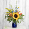 Sunflower bouquet in a blue glass vase with yellow and orange accents