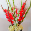 Tall red and white floral arrangement in a clear glass vase