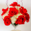 Red roses and white hydrangeas in a clear stemmed vase