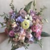 Handheld bouquet of pastel flowers in pink, lavender, and cream
