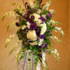 Tall floral spray with purple and white flowers on a stand