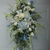 Tall white and blue floral standing spray on an easel