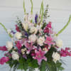 Tall floral arrangement with pink lilies, white roses, and purple accents