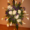 Tall floral standing spray with white calla lilies and purple flowers