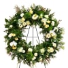Large floral wreath with white roses and orchids on a black stand