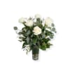 White roses in a clear glass vase with mixed greenery