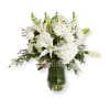 White floral arrangement in a glass vase with lilies and roses
